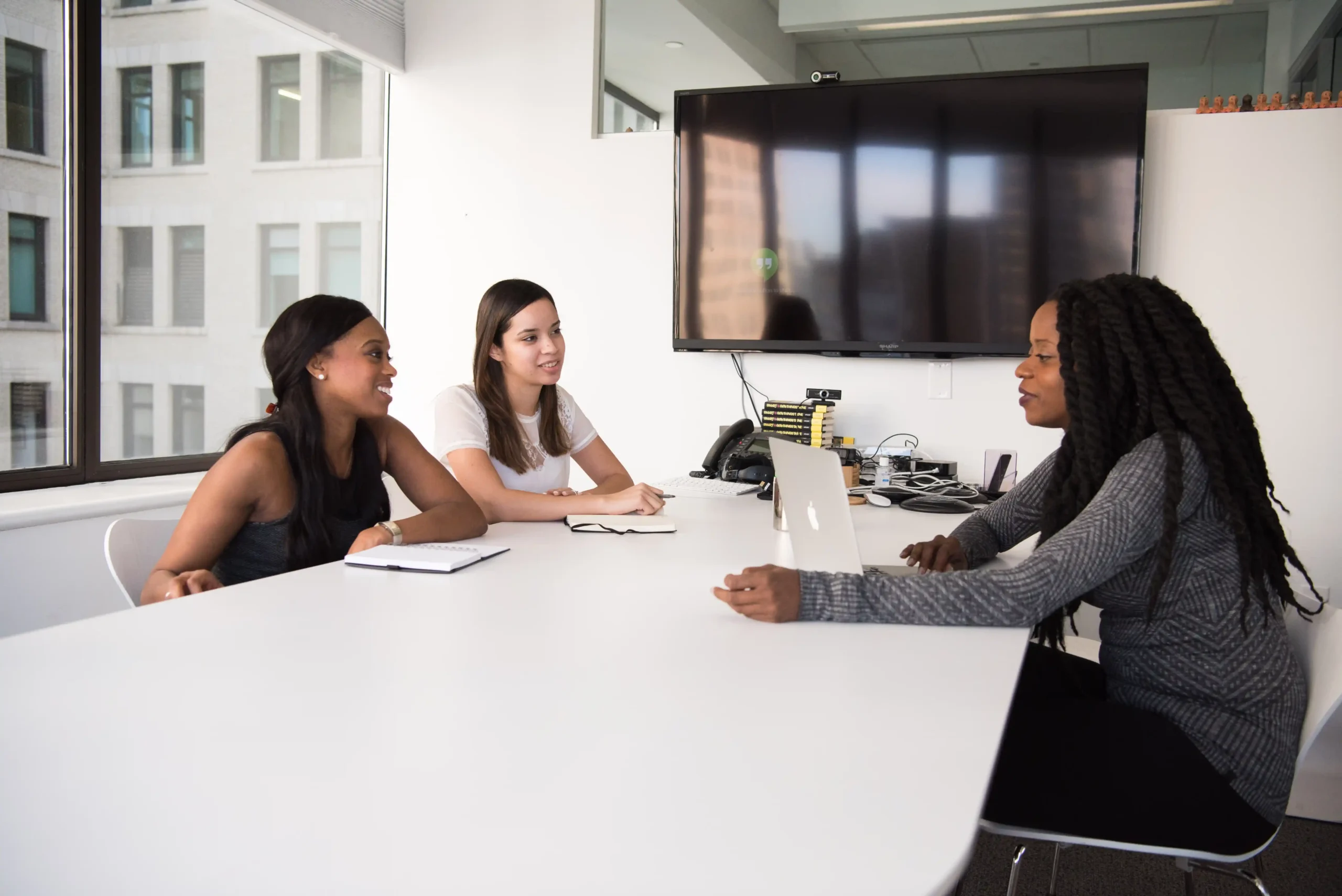 Three people sitting in a room and talking