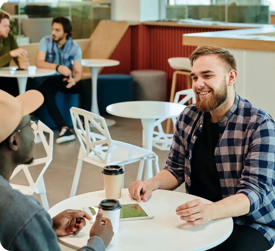 Two people having a conversation over coffee in a coworking space