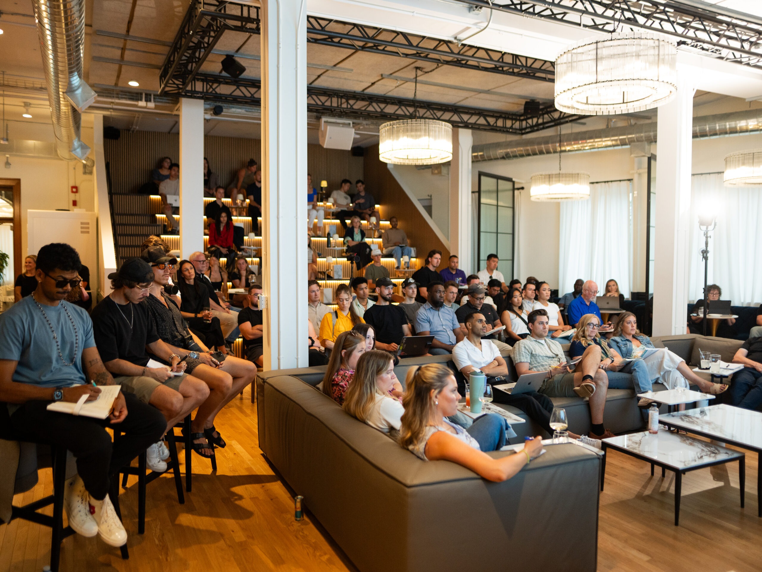 Members and guests filling the main lounge and tiered seating at Den 1880 during an event